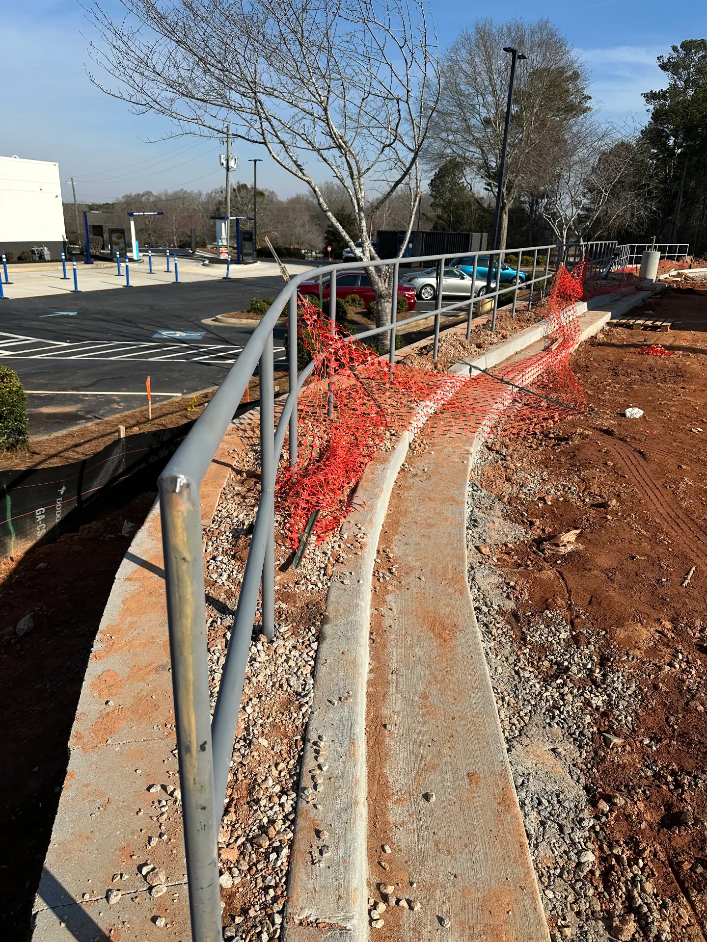 Curved pipe handrail following a sidewalk grade