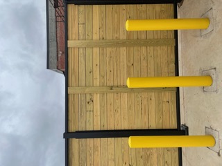 Steel-framed wood enclosure with protective bollards