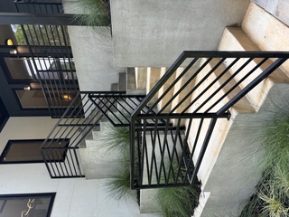 Black horizontal-bar exterior stair and guardrail at a modern home