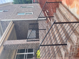 Black steel handrails on brick entry steps