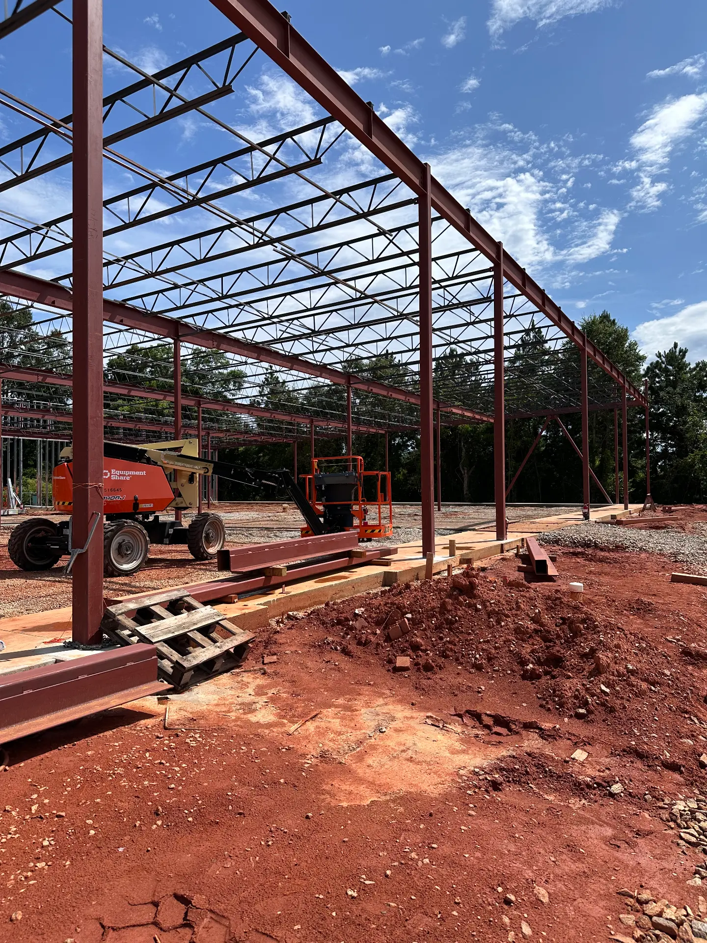 Red steel roof truss framing on a commercial build