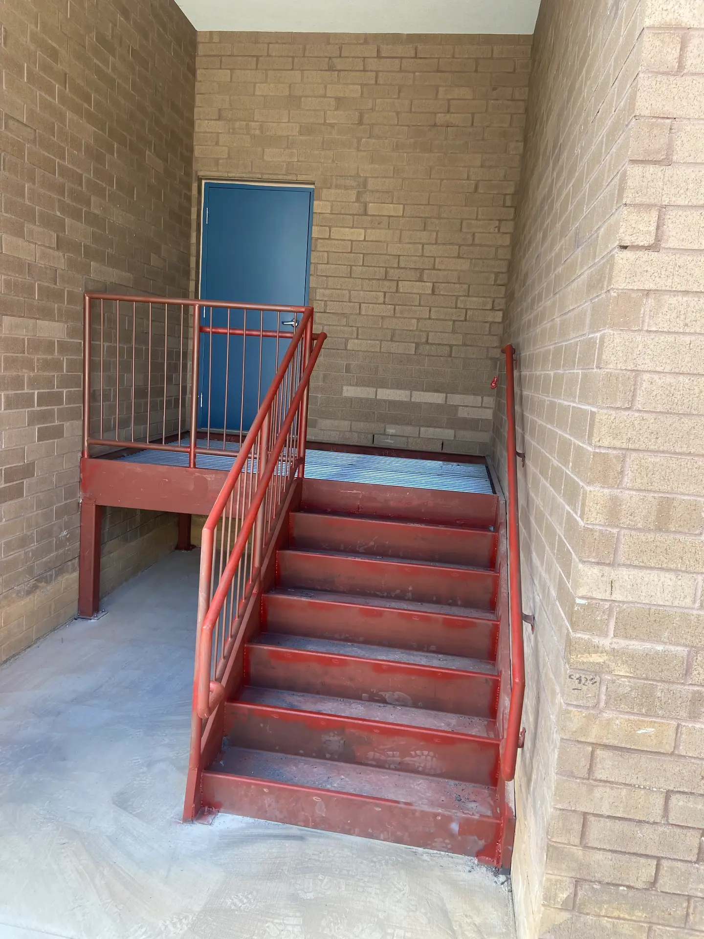 Steel stair, landing, and grating at a building entrance