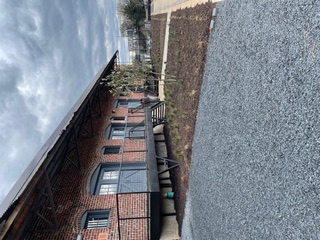 Elevated steel walkway and rail along a brick warehouse