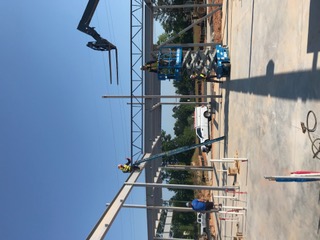 Crew erecting steel beams and joists with a lift