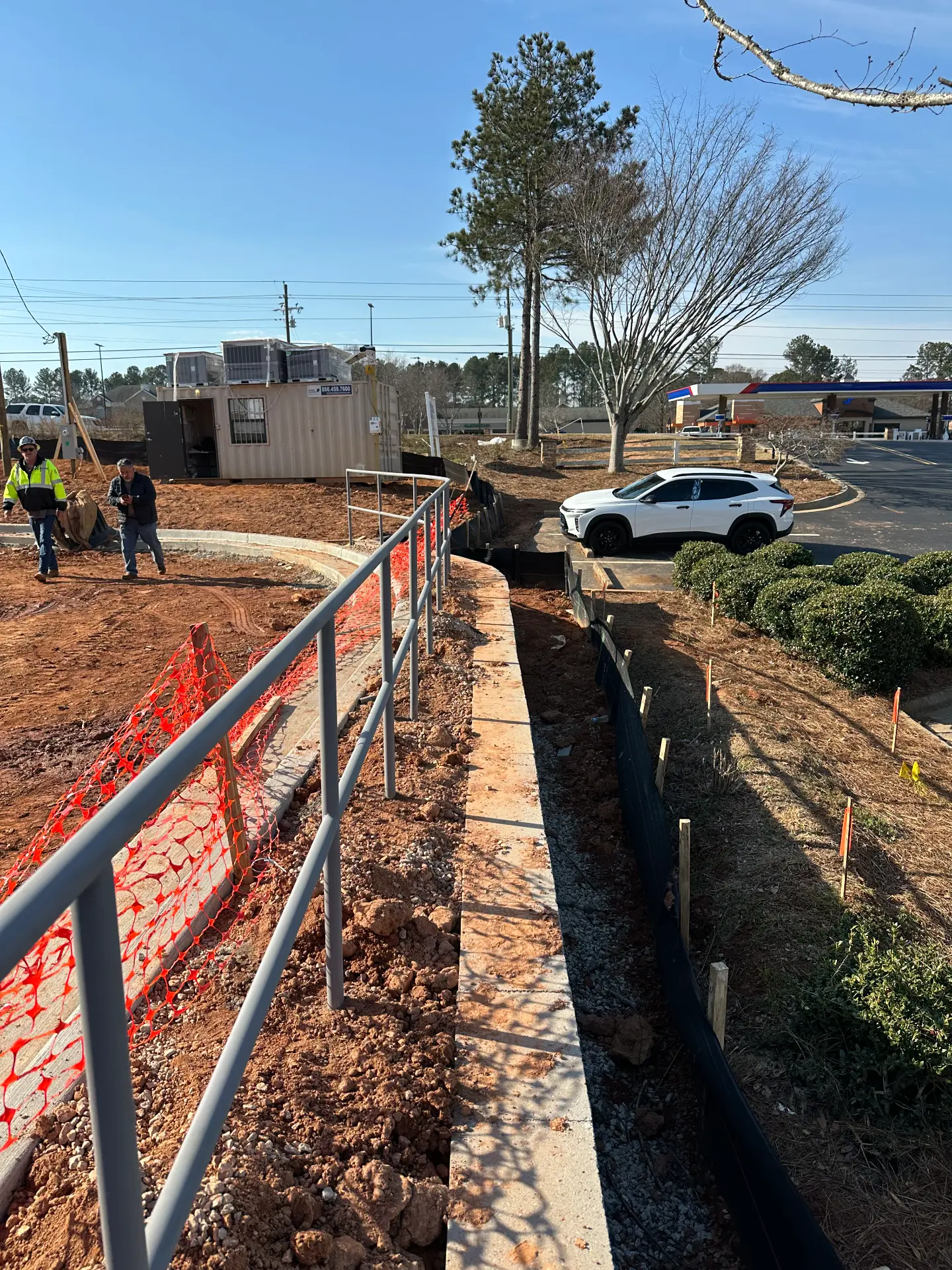 Pipe handrail installation on a new concrete walkway